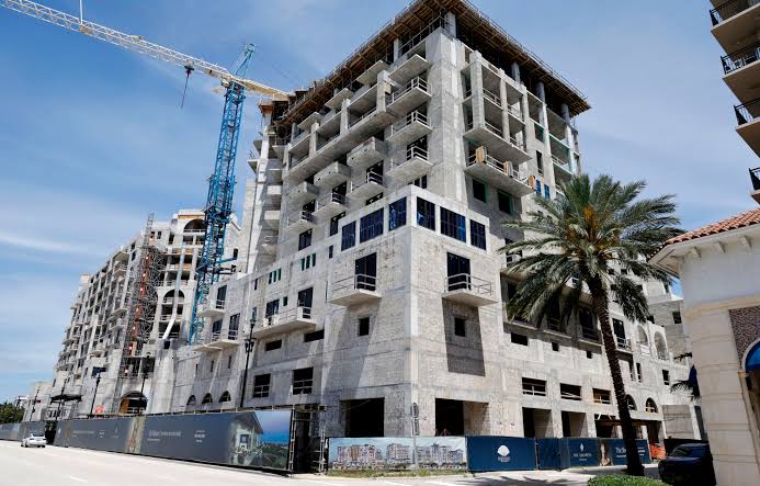 A luxury high-rise under construction with a tower crane — the long planning horizon behind an expensive commitment